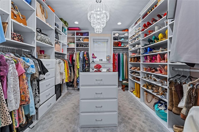 spacious closet featuring an inviting chandelier and light colored carpet