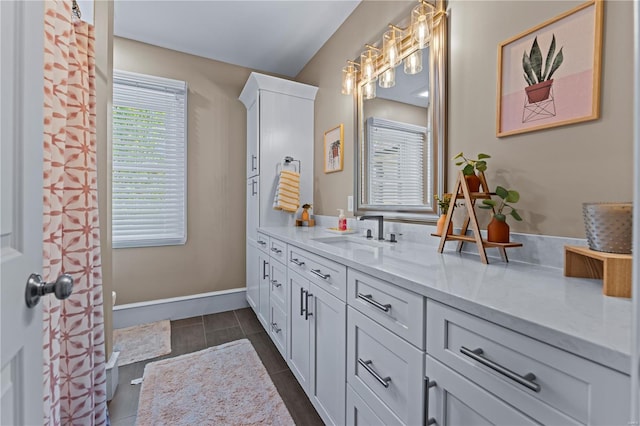 full bath with vanity and baseboards