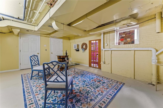 interior space featuring heating unit, baseboards, and brick wall