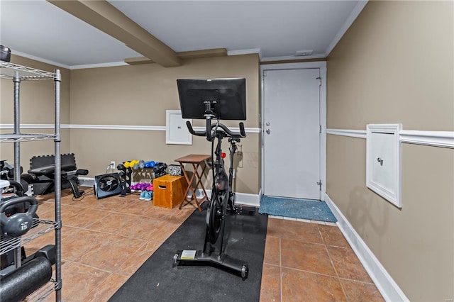 workout area featuring crown molding, tile patterned floors, and baseboards