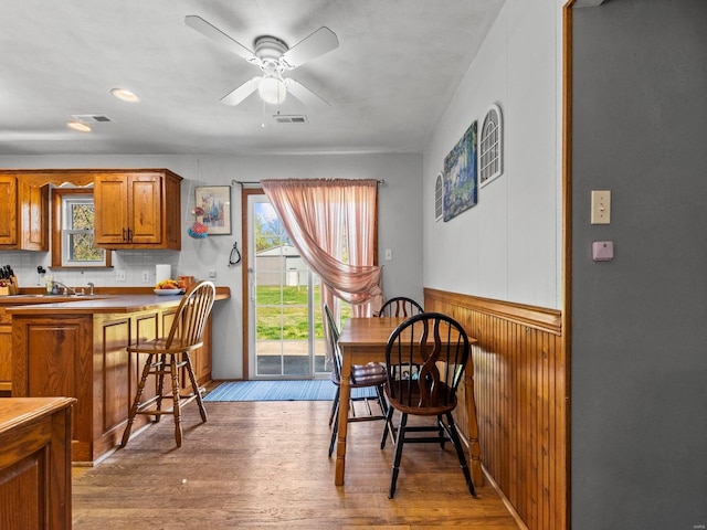 dining space featuring wood finished floors, visible vents, and a healthy amount of sunlight