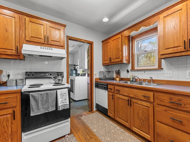 kitchen featuring backsplash, washer and clothes dryer, under cabinet range hood, and white appliances