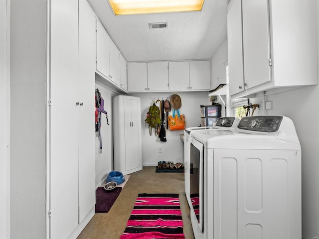 laundry room featuring washing machine and dryer, carpet floors, visible vents, and cabinet space