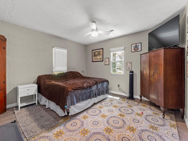 bedroom featuring ceiling fan, baseboards, and wood finished floors