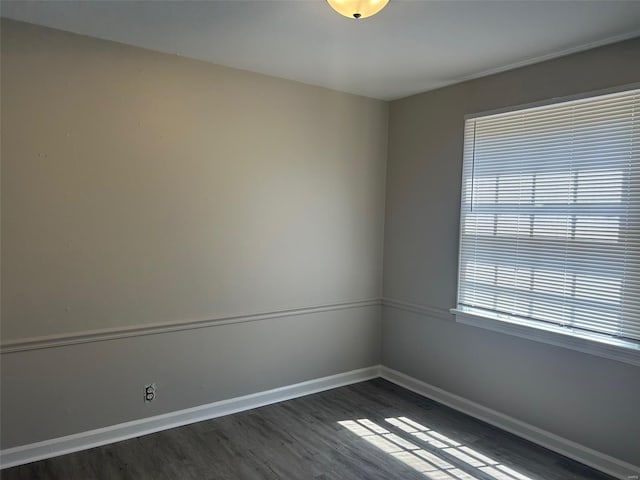 unfurnished room featuring dark wood-type flooring and baseboards