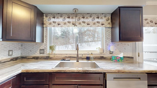 kitchen featuring dark brown cabinetry, decorative backsplash, dishwashing machine, and a sink