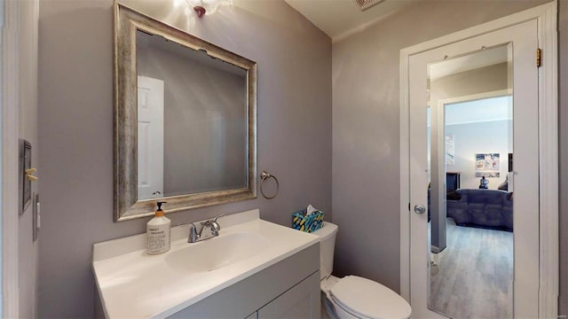 bathroom with visible vents, toilet, and vanity