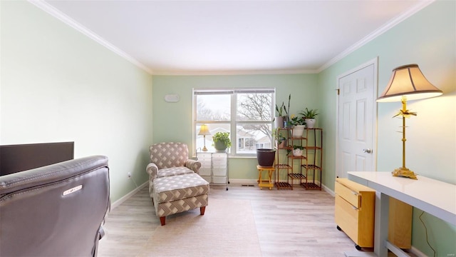 sitting room featuring light wood-style floors, crown molding, and baseboards