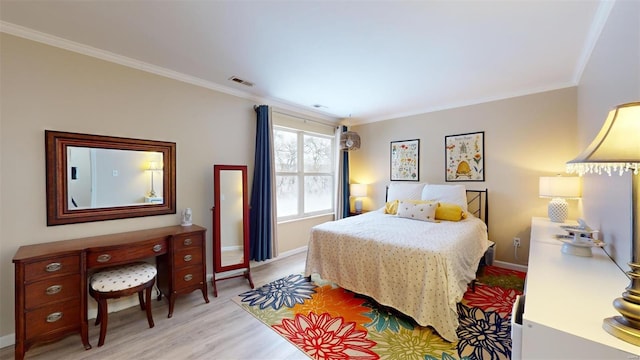 bedroom with light wood-type flooring, baseboards, visible vents, and ornamental molding