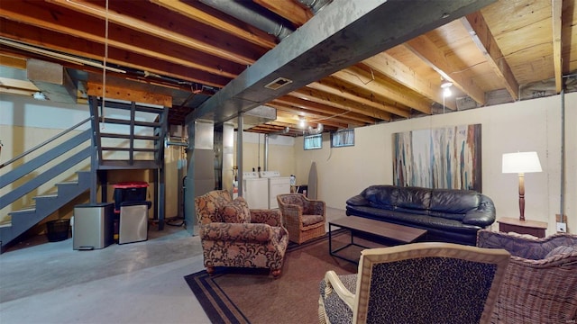 below grade area featuring visible vents, washer and clothes dryer, and stairs
