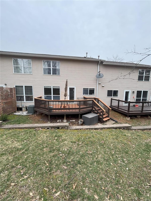 back of house with central air condition unit, a wooden deck, and a yard