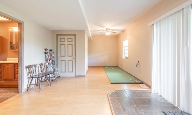 spare room with baseboards, wood finished floors, and a ceiling fan