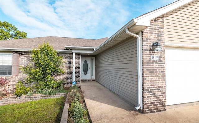 property entrance with brick siding and a garage