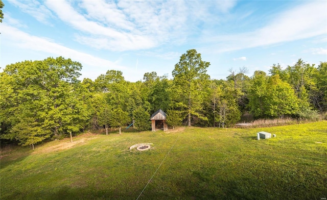view of yard featuring an outdoor fire pit, a gazebo, and a view of trees