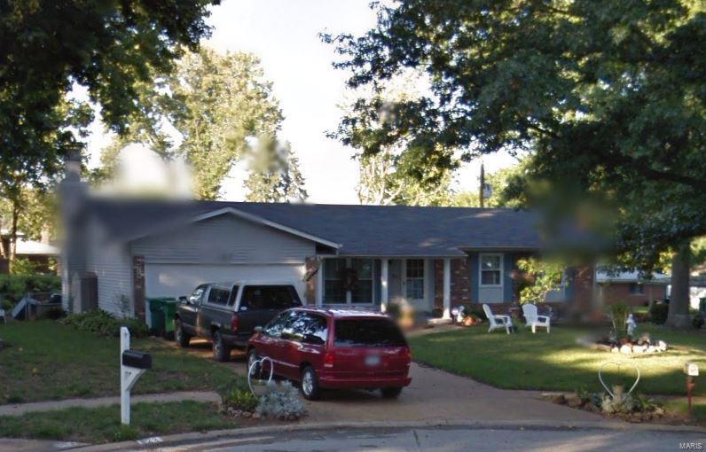 ranch-style home with a garage, a front lawn, and concrete driveway