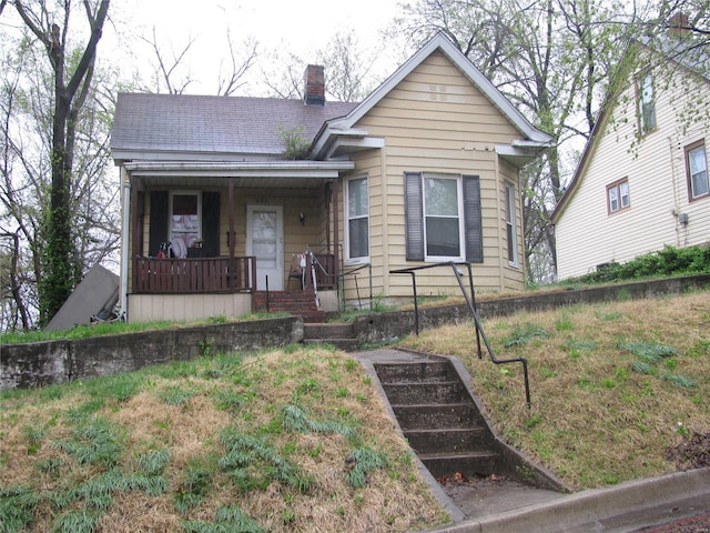 view of front of property with a porch and a chimney