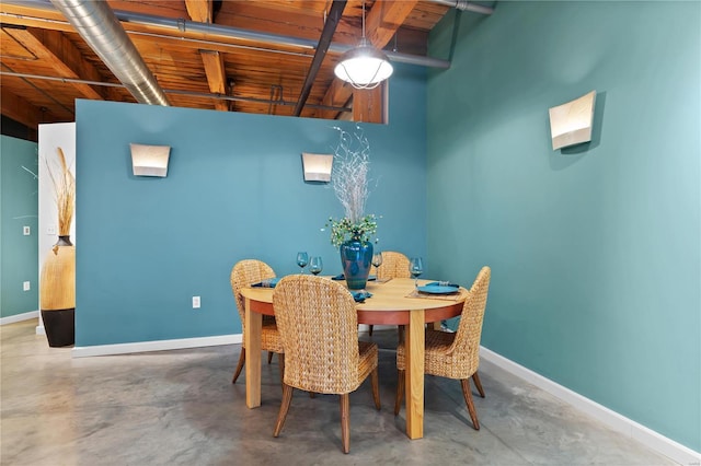 dining area featuring baseboards, beamed ceiling, wood ceiling, and concrete floors