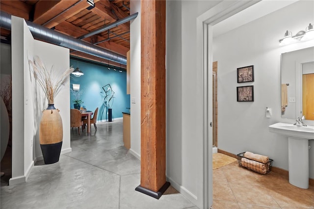 interior space featuring an enclosed shower, concrete flooring, and baseboards