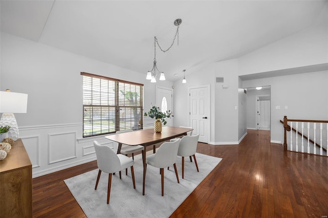 dining area with vaulted ceiling, wood finished floors, wainscoting, a chandelier, and baseboards