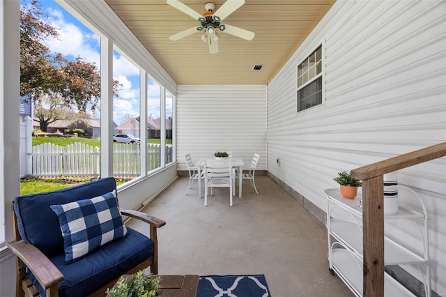 sunroom with a ceiling fan and outdoor dining area