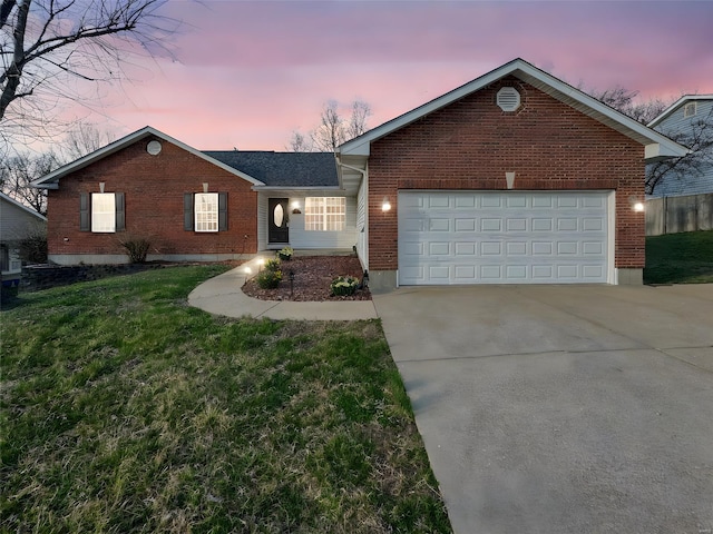 ranch-style house featuring brick siding, a yard, an attached garage, and concrete driveway