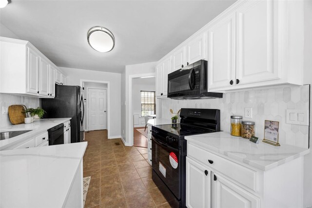 kitchen featuring black appliances, decorative backsplash, light stone counters, and white cabinets