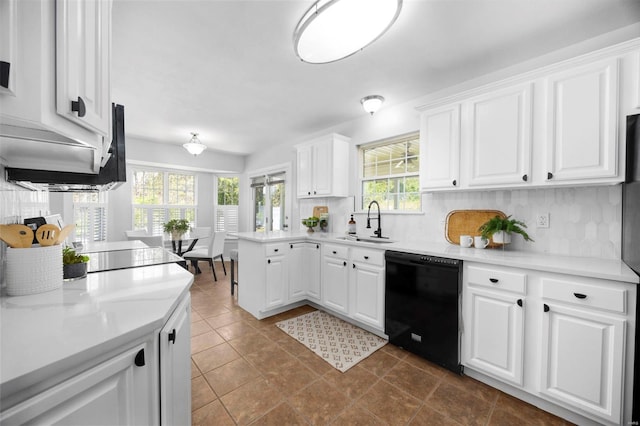 kitchen with light countertops, a sink, decorative backsplash, black dishwasher, and white cabinetry