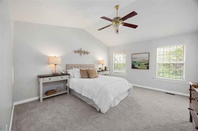 carpeted bedroom with vaulted ceiling, baseboards, and multiple windows