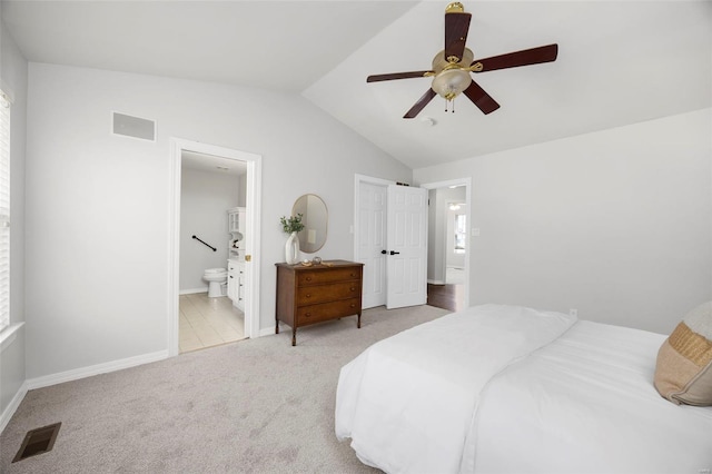 bedroom with connected bathroom, vaulted ceiling, carpet flooring, and visible vents