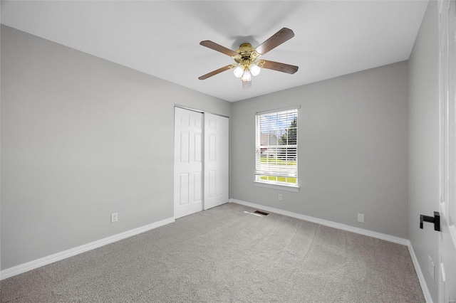unfurnished bedroom with a closet, visible vents, carpet flooring, and baseboards
