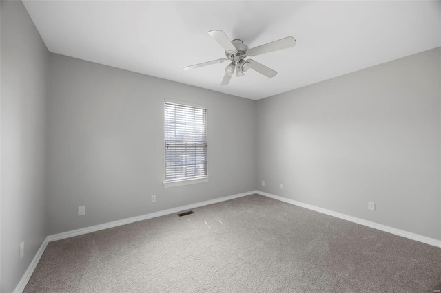spare room with baseboards, a ceiling fan, carpet flooring, and visible vents