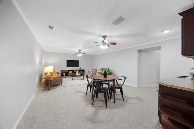 dining space with baseboards, visible vents, crown molding, and light colored carpet