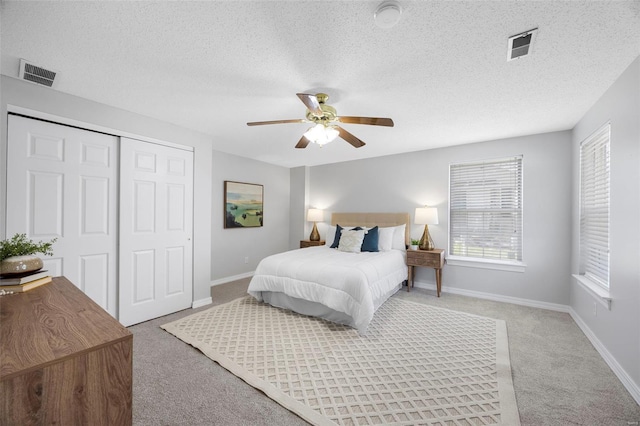 bedroom with baseboards, light carpet, visible vents, and a closet