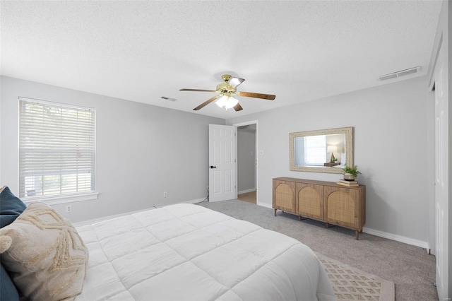 bedroom with visible vents, a textured ceiling, and carpet flooring