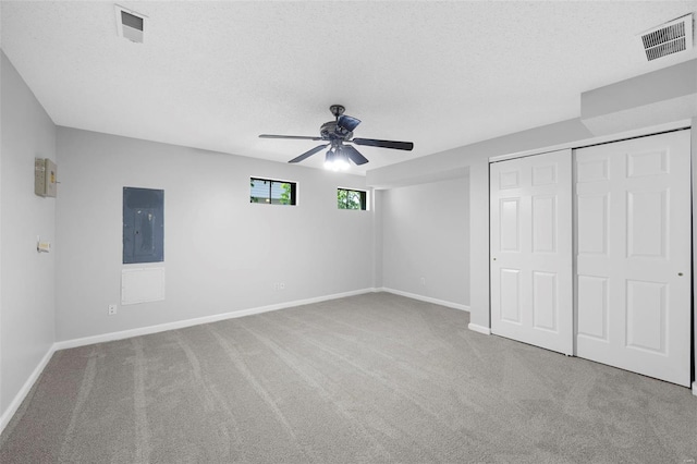 unfurnished bedroom featuring electric panel, baseboards, visible vents, and carpet floors
