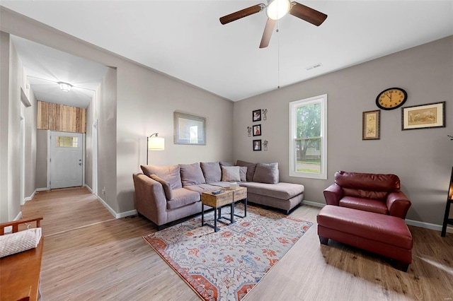 living area with baseboards, ceiling fan, visible vents, and light wood-style flooring