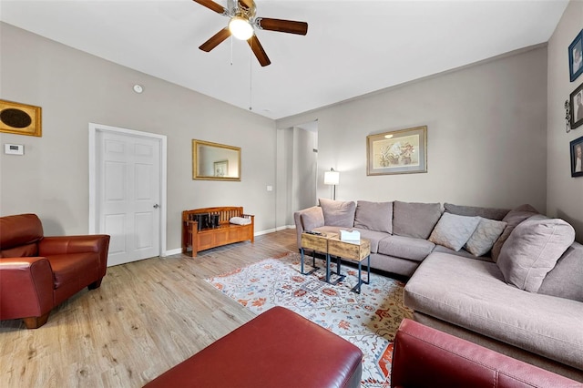 living area with baseboards, ceiling fan, and wood finished floors