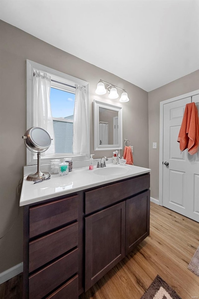bathroom featuring vanity, baseboards, and wood finished floors