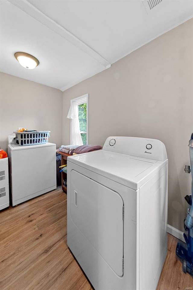 laundry room with separate washer and dryer, laundry area, and light wood-type flooring