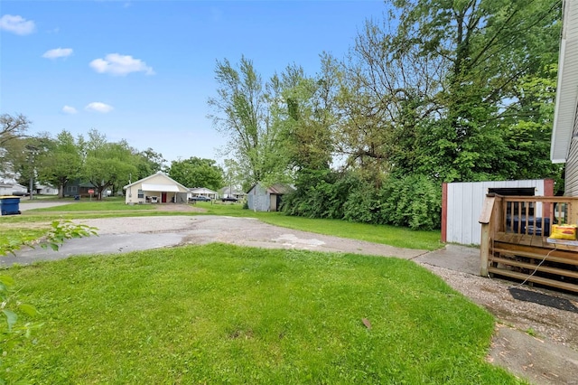 view of yard with a storage shed, an outbuilding, and a deck