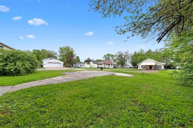 view of yard featuring a detached garage and driveway