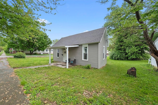view of front facade with roof with shingles and a front yard