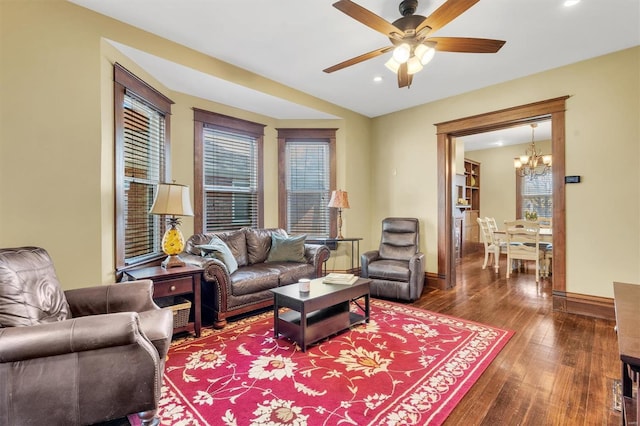 living room featuring recessed lighting, baseboards, dark wood-style floors, and ceiling fan with notable chandelier