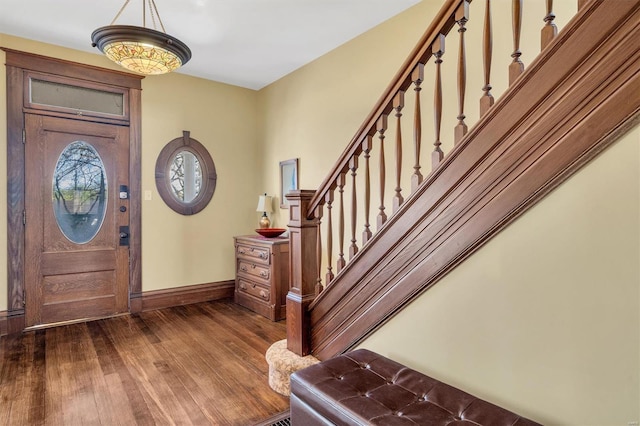entrance foyer featuring baseboards, stairs, and dark wood-style floors