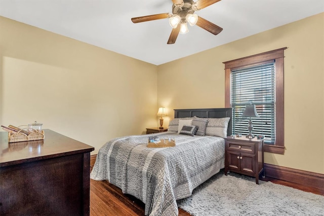 bedroom featuring wood finished floors, baseboards, and ceiling fan