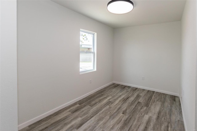 empty room with baseboards and wood finished floors