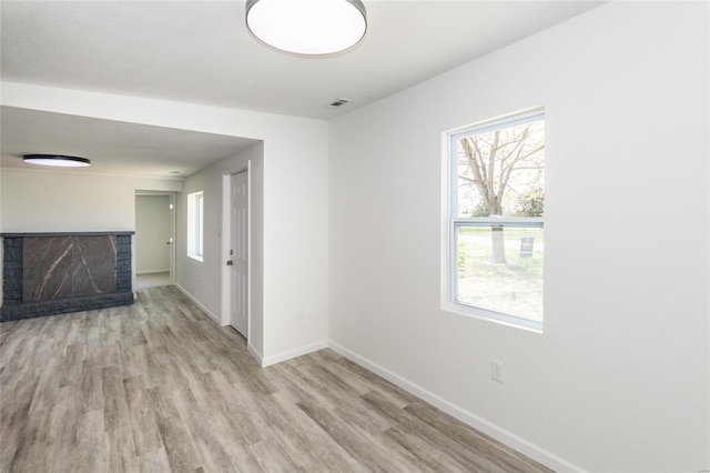 interior space featuring baseboards, a healthy amount of sunlight, and wood finished floors