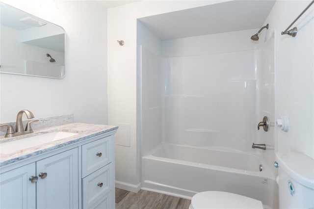bathroom featuring toilet, vanity, wood finished floors, and  shower combination