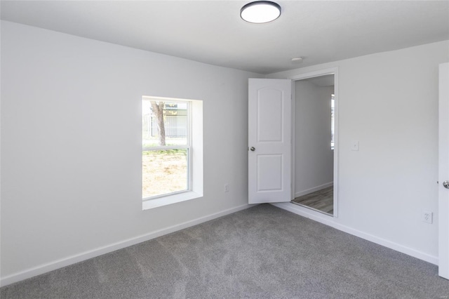 carpeted spare room with baseboards