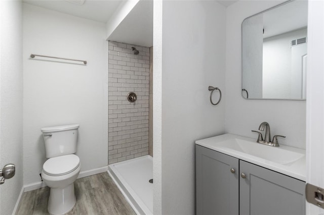 bathroom with vanity, a stall shower, toilet, and wood finished floors